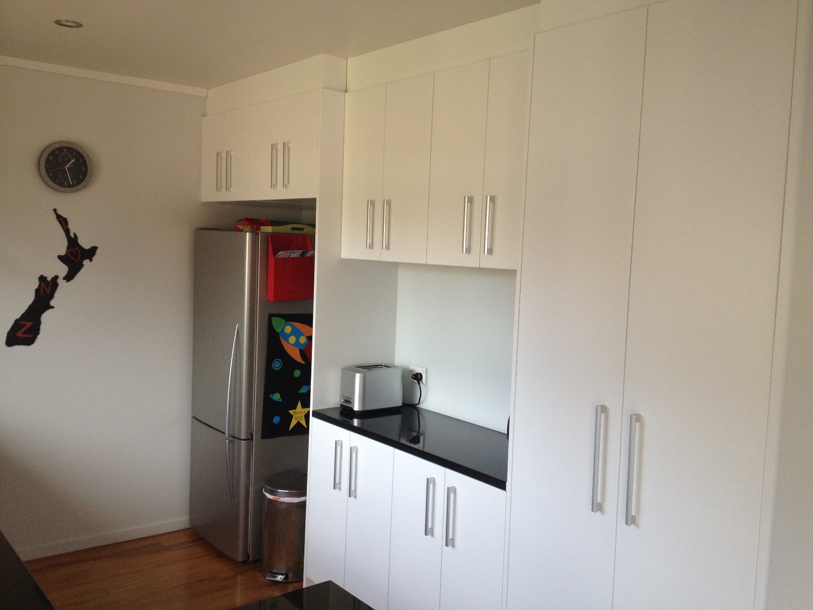 White doors with black top, full height pantry area